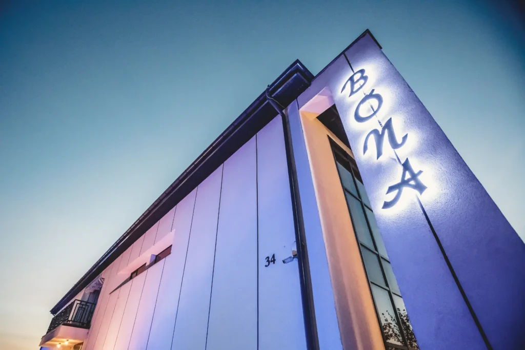 Zewnętrzne oświetlenie lokalu Bona w miejscowości Kuźnica – efektowna fasada budynku w nastrojowym świetle.